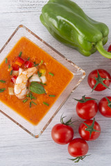 Soup gazpacho with shrimps. Italian Cuisine. Transparent bowl with soup on white tree background. Top View. Copyspace.