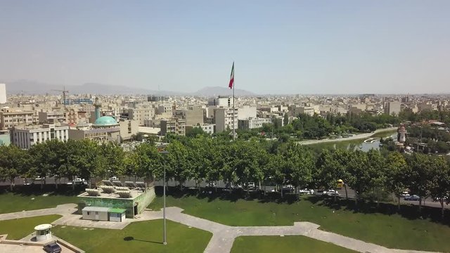 Aerial drone view of the city near the Azadi tower in Tehran. View of the waving Iranian flag. Iran 2018, may. A monument located at Azadi Square. 