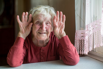 Portrait of an elderly woman playful with a kind face.