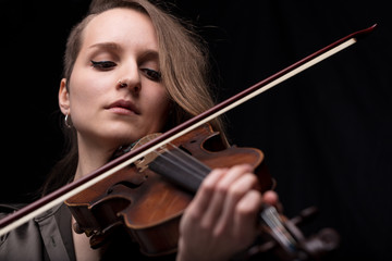 Fototapeta premium passionate violin musician playing on black background