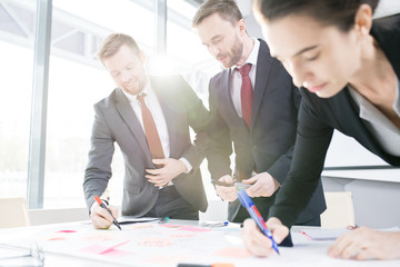 Portrait of successful business team actively collaborating on strategy project in sunlight