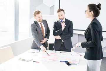 Portrait of successful business team standing at table and actively collaborating on strategy project, copy space