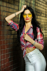 Fototapeta premium Gorgeous young model woman with perfect figure wearing trendy outfit posing in the city street.