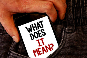 Handwriting text What Does It Mean Question. Concept meaning Confusion Curiosity Questioning Inquire Brown jeans back pocket hand pushing mobile phone with black and red text.