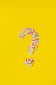 question mark on a  background from multi-colored confetti, from pieces of color paper.
