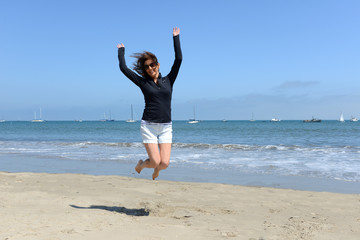 Woman jumping at the ocean shore
