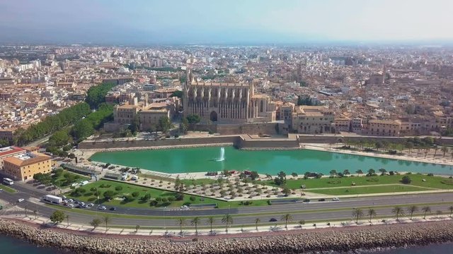 Aerial view Cathedral of Palma de Mallorca and Almudaina Castle. Beautiful gothic architecture overlooking the sea shore, Mallorca island, Spain.
