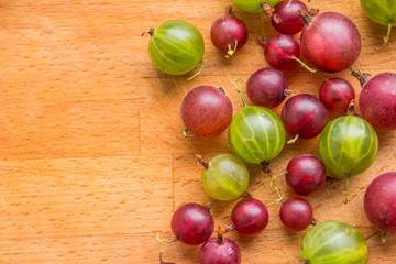 ripe gooseberry lies on a wooden surface.Fresh ripe red and green gooseberry.diet, vegetarianism, vegan food, organic berries. Copy space
