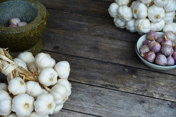 Fresh raw garlic bundle on cutting board, traditional mortar, copy space, kitchen raw ingredient concept