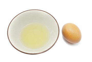 Top view of egg and egg white in a bowl isolated on black background. Copy space