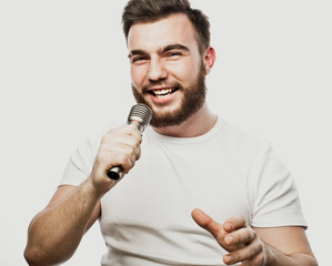lifestyle and people concept: young man singing with microphone