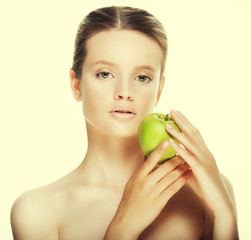 Head shot of woman holding green apple against white background