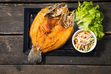 Deep fried seabass fish in black soy sauce, called Pla Krapong Tord Nam Plar Thai Food