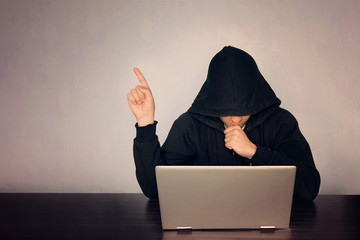 Hacker hooded in front of his computer show finger. Dark face. hooded .technology concept, hacker...