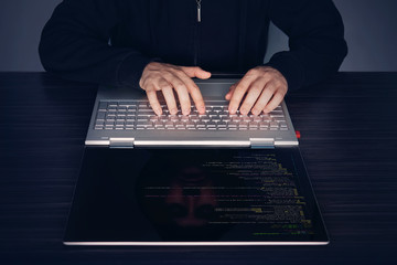 Hacker using laptop. Lots of digits on the computer screen. modern slim ultrabook transformer on...