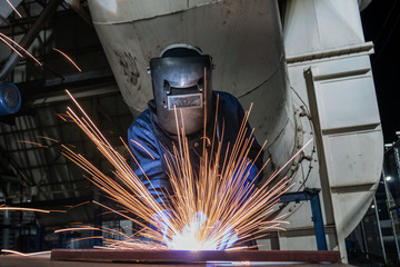Industrial worker is welding repair steel part