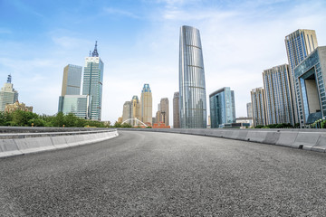 Fototapeta na wymiar The empty asphalt road is built along modern commercial buildings in China's cities.