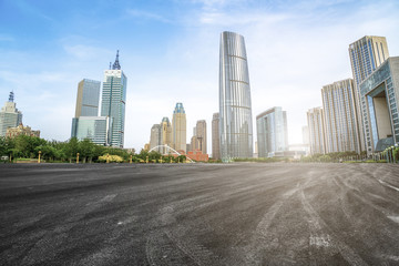 The empty asphalt road is built along modern commercial buildings in China's cities.