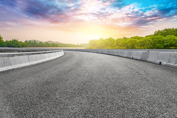 The empty asphalt road and natural landscape under the blue sky