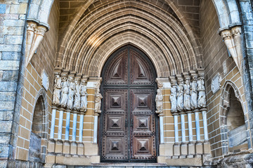 Wooden door on brick wall church in Evora Portugal