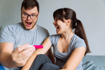 Fototapeta premium happy couple looking on pregnancy test