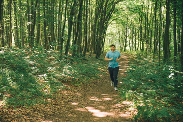 adult young man running in woods. copy space. smiling