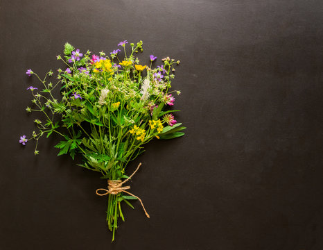 A bouquet of fresh summer flowers rests on a graffiti background. Natural summer concept. Copy space. A place for design. Flat layout.