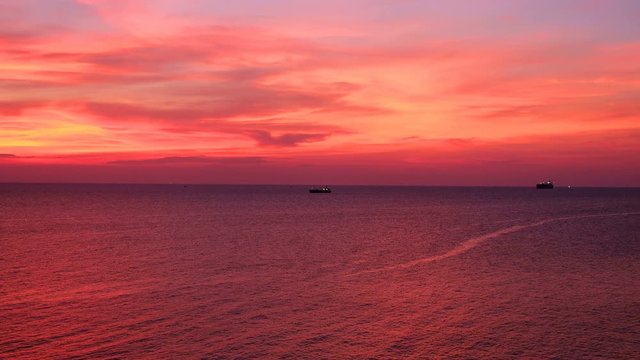 Dramatic sunset seascape pink and orange sky twilight view with silhouette oil tanker ship from koh sichang, chon buri, thailand, UHD 4K video with copy space