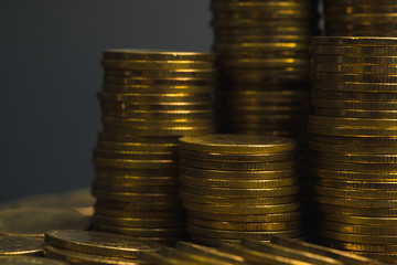 Savings, increasing columns of coins, piles of coins arranged as a graph in dark room, business banking concept.