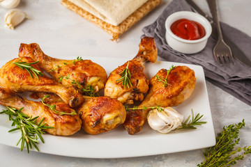 Grilled spicy chicken legs baked with garlic, rosemary and thyme on white background.