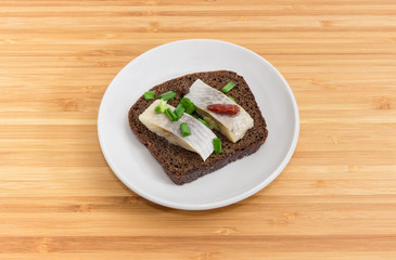 Open sandwich with slices of pickled herring and brown bread