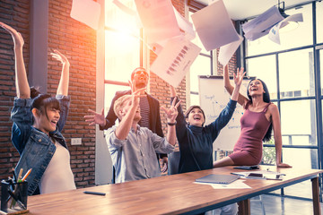 Diverse business team throwing paper when meeting success with happy emotion together, people with...