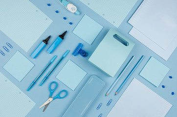 Blue office stationery collection on soft pastel blue paper  background, top view.