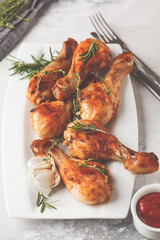 Grilled spicy chicken legs baked with garlic, rosemary and thyme on white background.