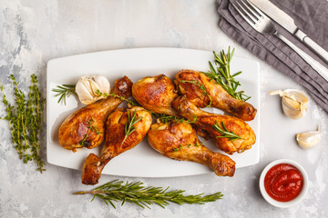 Grilled spicy chicken legs baked with garlic, rosemary and thyme on white background.
