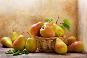 fresh pears with leaves in a basket