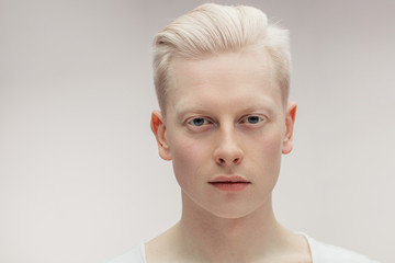 Fashion albino model man portrait isolated on white background. Stylish haircut, perfect skin. Man Beauty and Healthy Skin Care Concept - obrazy, fototapety, plakaty