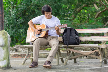 The guy playing the guitar, outdoor, cargo pants