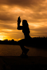 Women are playing yoga at Reservoir area with Sunset
