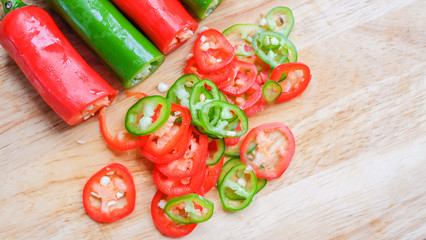 Sliced green and red chili on wooden chopping board