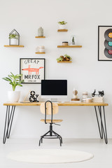Front view of a desk with a computer, plant and books on the top, shelves on the wall and chair. Place your product