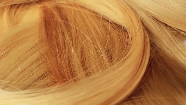 Hair extension cutted hair fibers blonde weft rotating pattern macro texture background backdrop footage video.