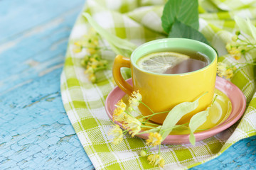 Cup of herbal tea with linden blossoms and lemon