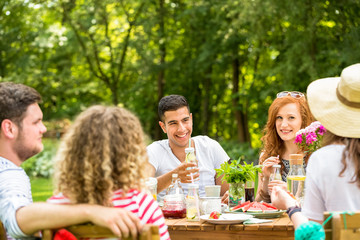 Happy red-haired woman and her spanish friend enjoying garden party