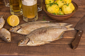 Dried fish with beer on wooden background