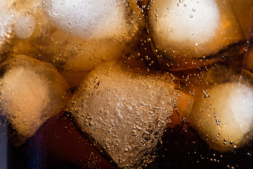 Cola with ice cubes in a close-up glass