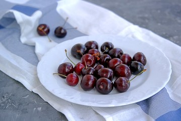 Ripe juicy cherry on a white plate. Summer concept