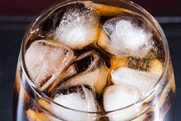 Cola with ice cubes in a close-up glass