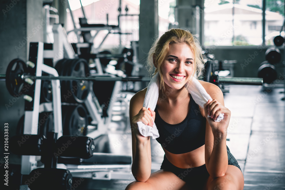 Wall mural woman relaxing after finishing workout and weight trianing at sport gym