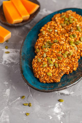 Vegan oatmeal pumpkin cookies on a blue dish, halloween food, autumn food, vegan food concept.